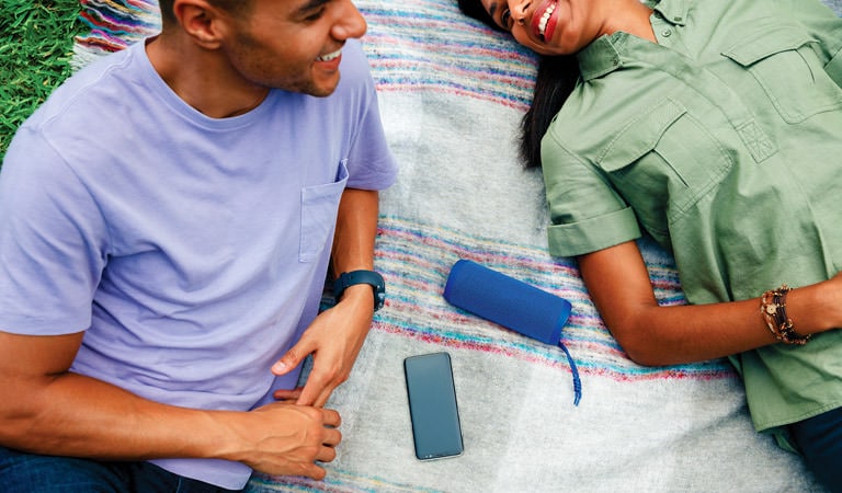 Man and woman listening to music from smartphone