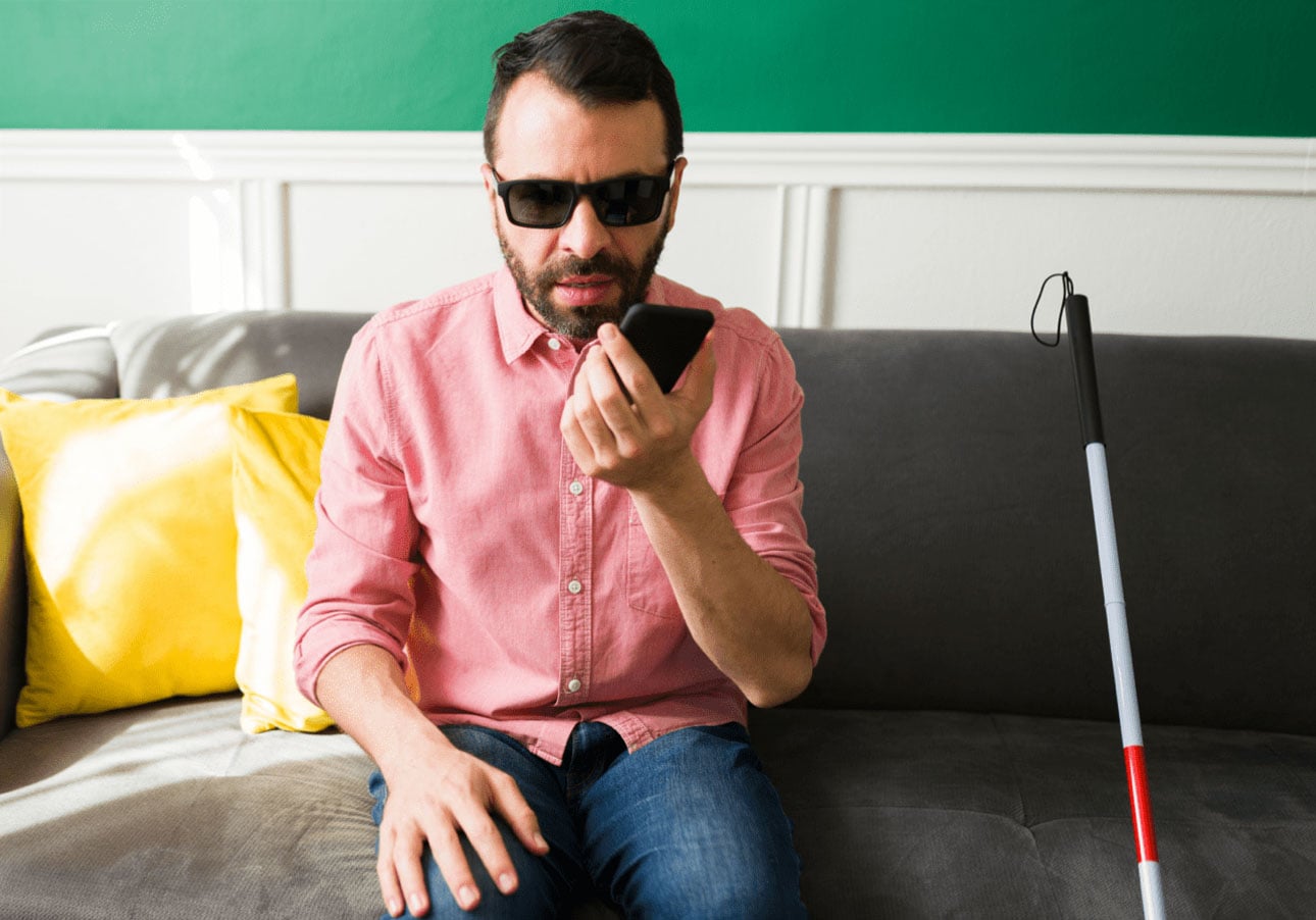 A visually impaired man using a smart phone to communicate.
