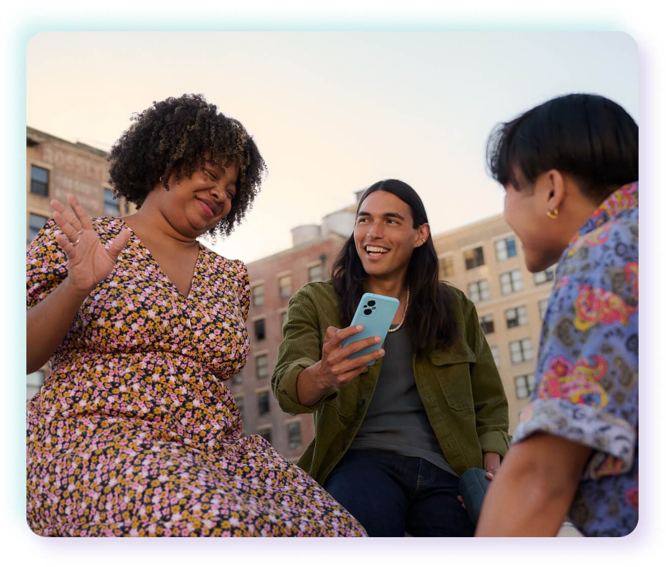 group of friends laughing around phone