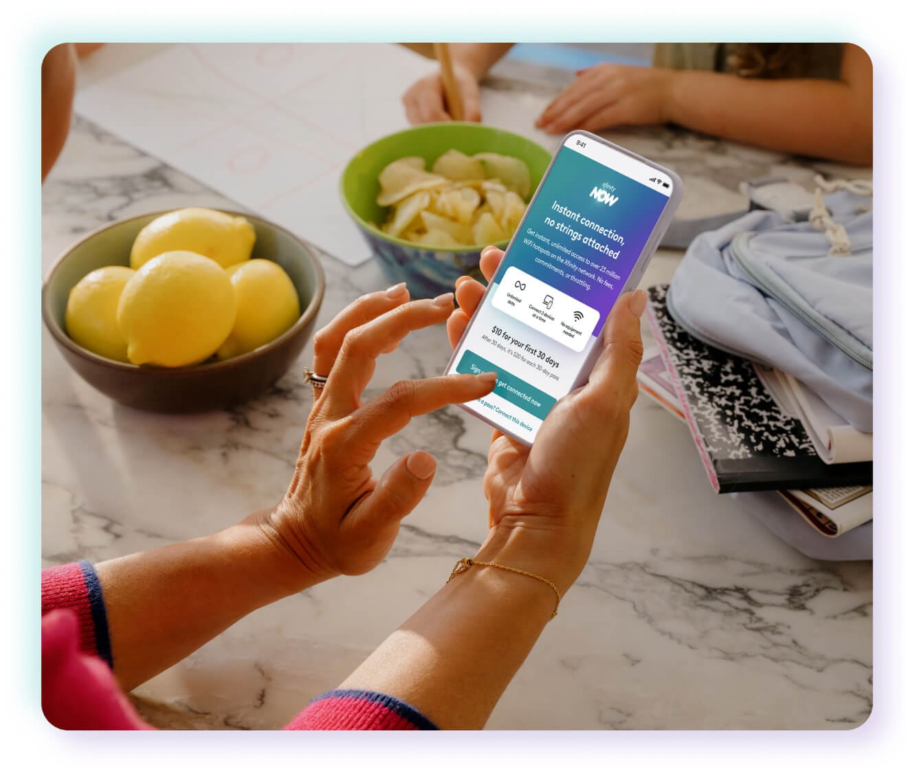 woman's hands hovering over button on phone app near kitchen tablet